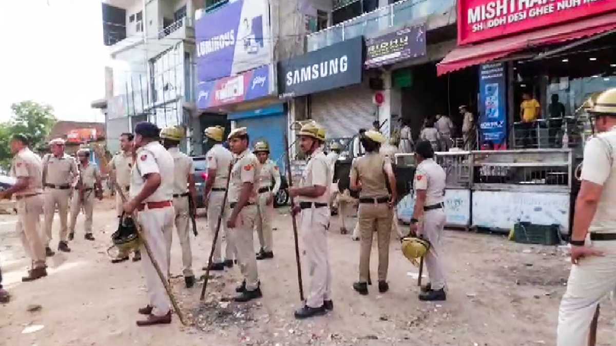 Police personnel stand guard at an area in Nuh. (Photo Credit: ANI)